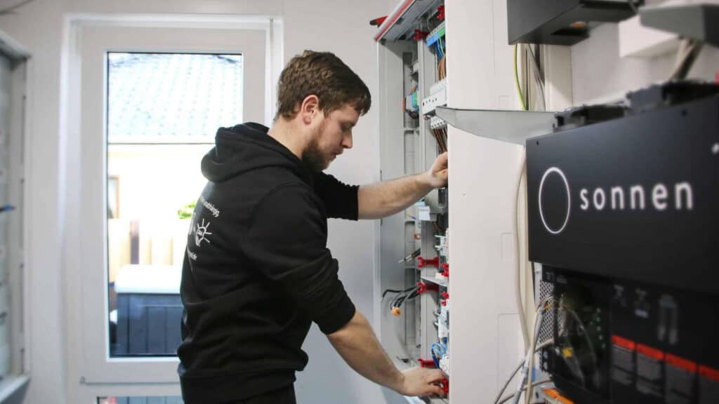 Elektriker der Energieinsel baut eine sonnen Batterie ein