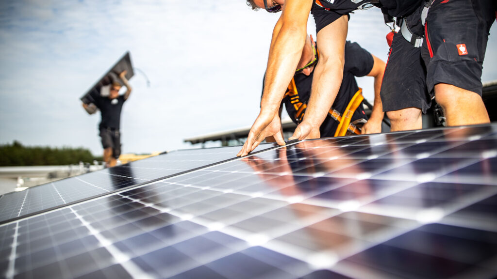 Dachdecker der Energieinsel bei der Montage von PV Modulen